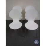 Four contemporary white dining chairs on chrome legs