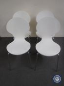 Four contemporary white dining chairs on chrome legs