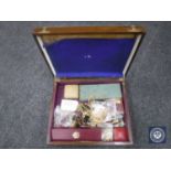 A wooden box containing a quantity of costume jewellery.