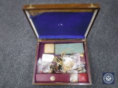 A wooden box containing a quantity of costume jewellery.