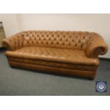 A tan leather Chesterfield style three seater settee,