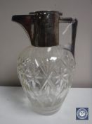 A cut glass jug with silver lid and handle,