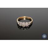 An 18ct gold and platinum set three stone diamond ring, approximately 0.25ct, size K 1/2.