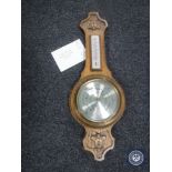 A carved oak cased banjo barometer by Comitti of London