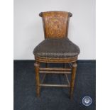 A breakfast bar stool with tooled leather panelled back