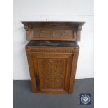 An antique carved oak wall cabinet and a similar wall shelf