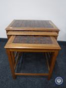 A nest of three 1970's teak tiled topped tables