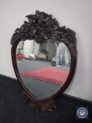 A reproduction mahogany heart shaped mirror with leaf and grape design