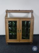 A continental oak wall cabinet with leaded glass doors