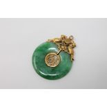 A green jade disc pendant set in high carat gold CONDITION REPORT: 4.5g.