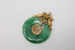 A green jade disc pendant set in high carat gold CONDITION REPORT: 4.5g.