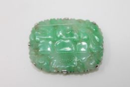 A carved jade plaque set in white metal CONDITION REPORT: 2.8cm by 3.9cm.