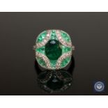 A 14ct white gold emerald and diamond ring, the central, oval-cut, deep-green emerald weighing 1.