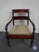 An antique stained pine scroll arm chair