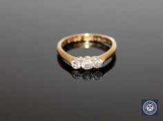 An 18ct gold three stone ring, approximately 0.33ct, size K.