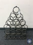 A cast iron eighteen bottle wine rack