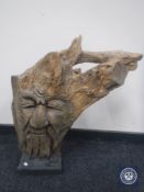 A Greenman wooden carving on stand
