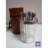 Three vintage hips flasks in a cylindrical leather case
