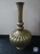 A brass Eastern vase with embossed flower decoration,