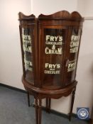 A pair of glazed mahogany bowfront display cabinets with 'Fry's Chocolate' advertising,
