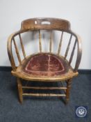 An antique oak leather seated captains armchair