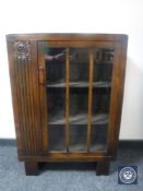 A 1930's oak single door display cabinet