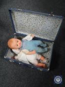 Two mid 20th century luggage cases containing two plastic headed dolls