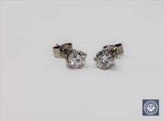 A pair of solitaire diamond stud earrings, the total diamond weight estimated at 0.