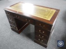 A mahogany twin pedestal desk fitted nine drawer with green tooled leather inset panel