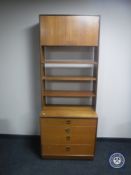 A mid 20th century teak G-Plan shelving unit fitted four drawers beneath