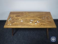 An inlaid walnut coffee table depicting figures working in a field