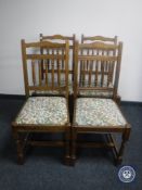 A set of four oak tapestry upholstered dining chairs