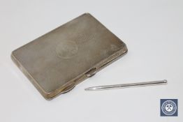 An antique silver card case containing a silver pencil
