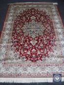 A Keshan carpet on red ground, 2.30 m x 1.