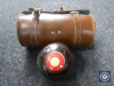 A pair of antique leather cased lawn bowls