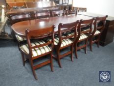 An inlaid mahogany Regency style twin pedestal dining table with leaf together with eight single