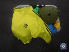 A plastic crate containing a large quantity of active wear clothing,