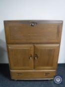 An Ercol elm cocktail cabinet