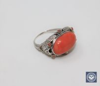 An antique coral ring set in white gold,