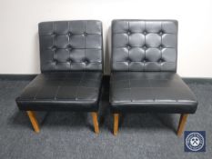 A pair of mid 20th century black buttoned vinyl upholstered chairs on teak legs