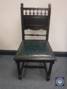 An Edwardian carved oak leather seated hall chair