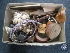 A box containing wooden pieces including carved wall mask, wooden fruit,
