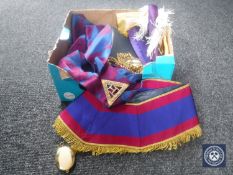 A box containing Masonic regalia including sashes and Bible