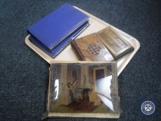 A tray containing two albums of vintage postcards, unframed chrystoleum,