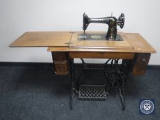 A mid 20th century Singer treadle sewing machine in oak table