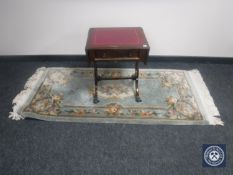 A mahogany flap sided table and a green fringed Chinese rug