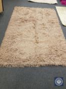 A contemporary shaggy pile rug on beige ground,