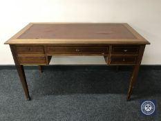 A Victorian inlaid mahogany five drawer writing desk with brown leather inset panel