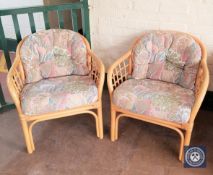 A pair of wicker conservatory armchairs