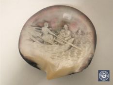 A relief carved mother of pearl shell depicting a family in a rowing boat,